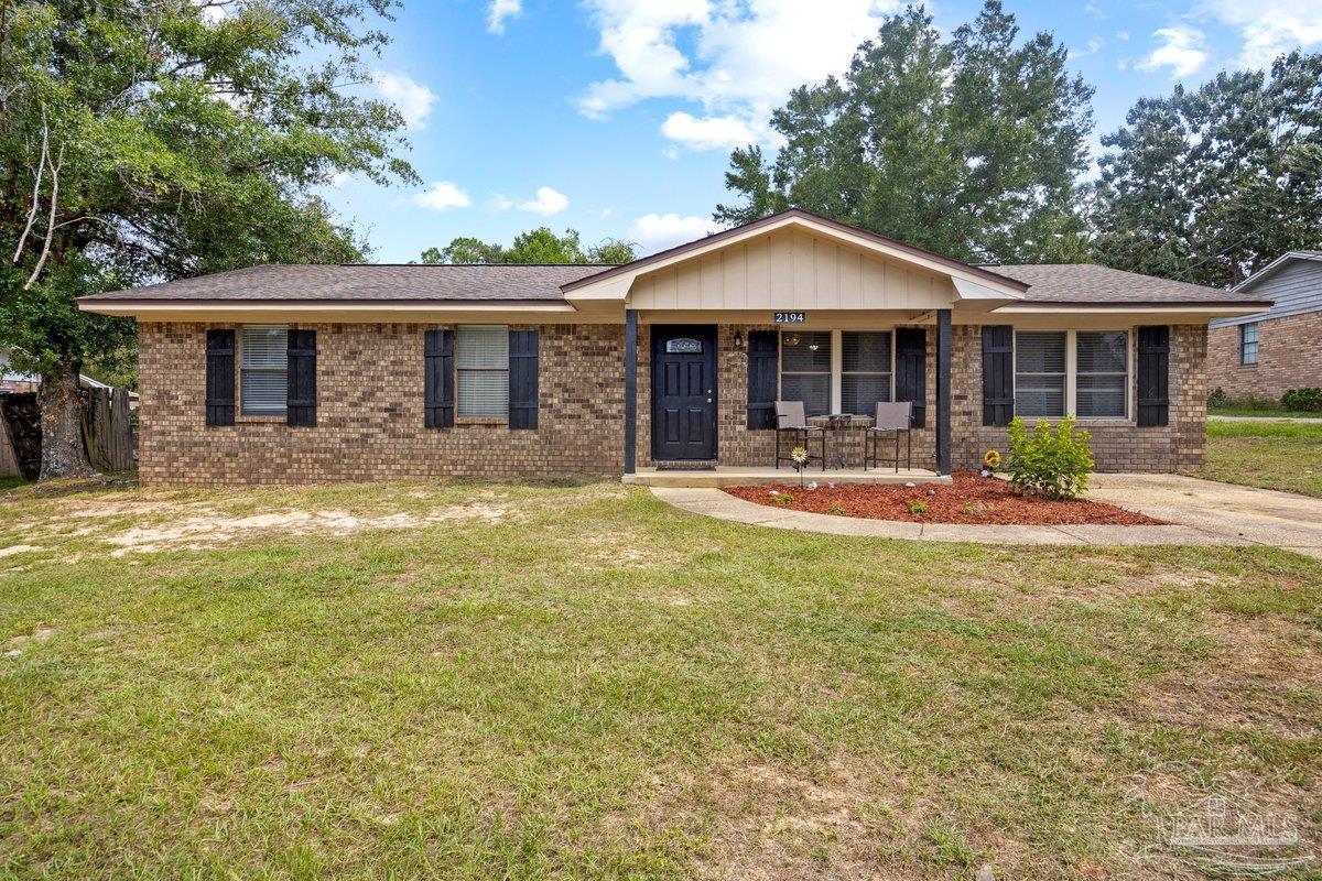 2194 Pompano Street Cantonment, FL 32533 - Photo 1 of 23 a front view of a house with a yard table and chairs