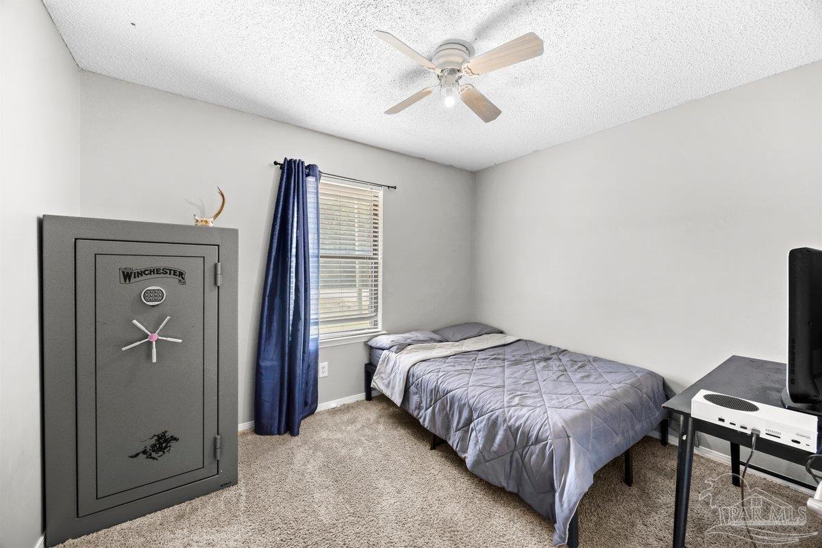 2194 Pompano Street Cantonment, FL 32533 - Photo 12 of 23 a bedroom with a bed and a chandelier