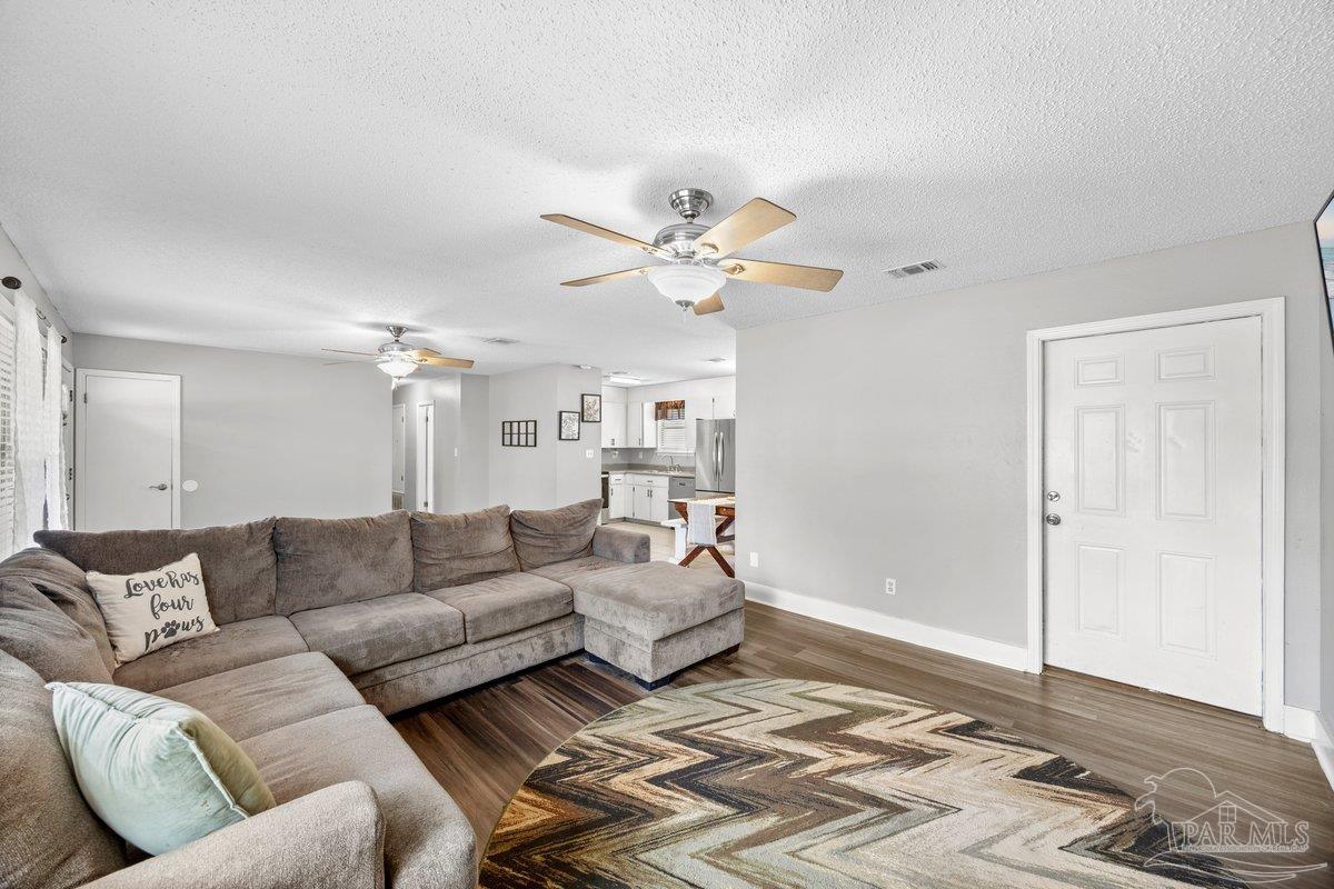 2194 Pompano Street Cantonment, FL 32533 - Photo 4 of 23 a living room with furniture ceiling fan and a rug