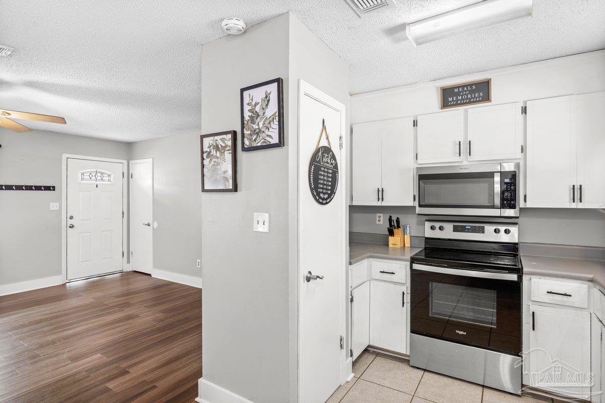 2194 Pompano Street Cantonment, FL 32533 - Photo 6 of 23 a kitchen with stainless steel appliances a stove a microwave and a refrigerator