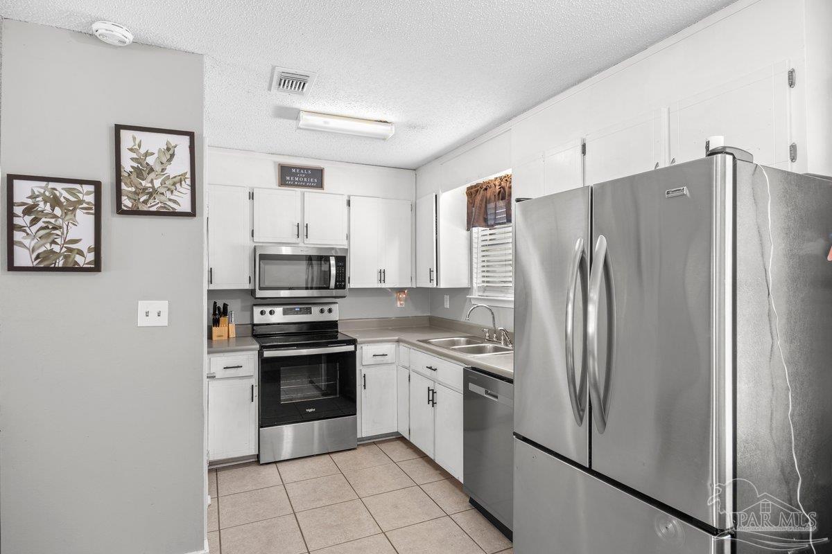 2194 Pompano Street Cantonment, FL 32533 - Photo 7 of 23 a kitchen with stainless steel appliances a refrigerator sink and stove