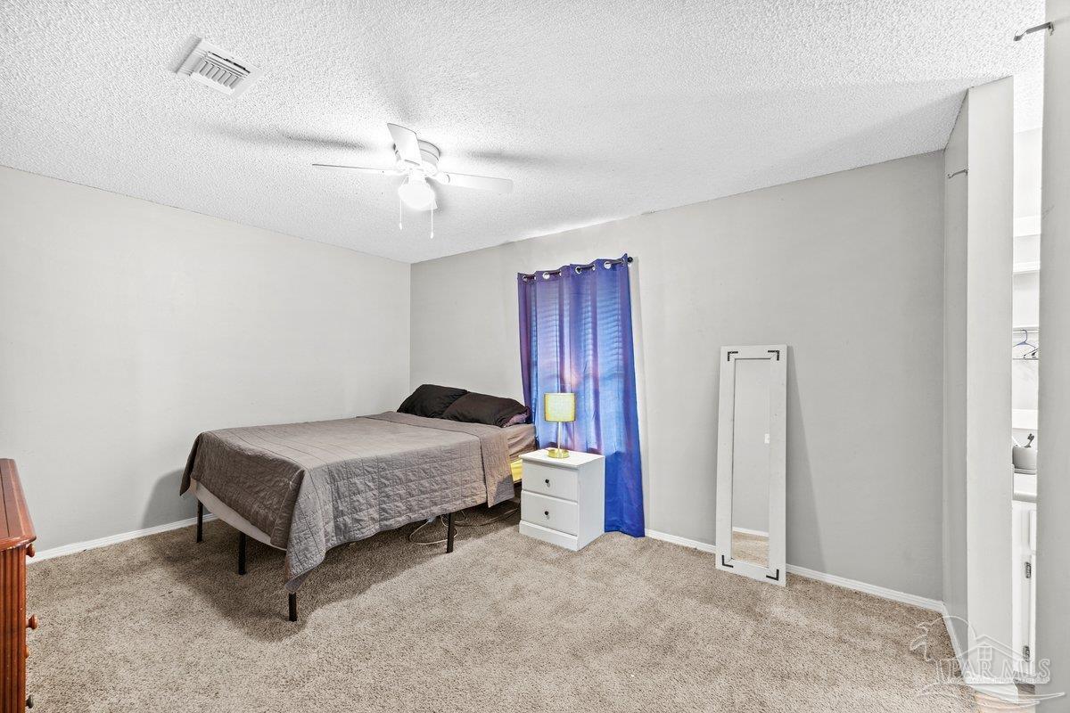 2194 Pompano Street Cantonment, FL 32533 - Photo 10 of 23 a bedroom with a bed and a chandelier