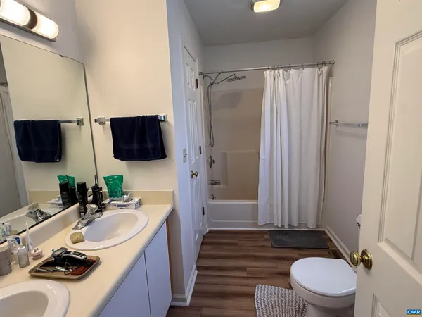 a bathroom with a sink toilet double vanity and shower