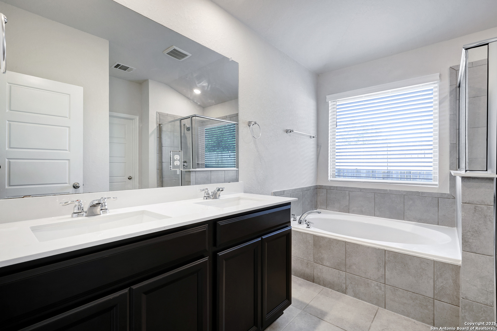 3168 Junction Bay Converse, TX 78109 - Photo 12 of 26 a bathroom with a bathtub double vanity sink and mirror