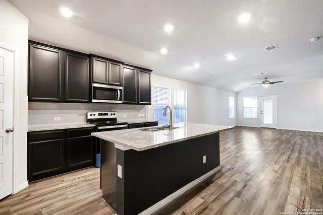 a kitchen with stainless steel appliances granite countertop a sink dishwasher stove and refrigerator