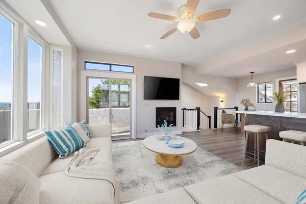 a living room with furniture a flat screen tv and a large window
