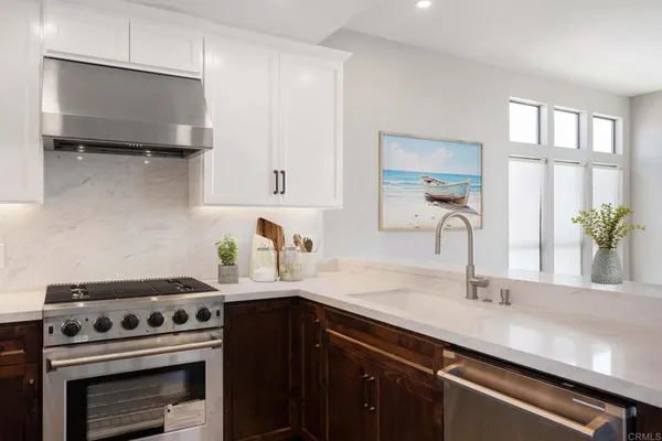 a kitchen with a sink a stove and cabinets