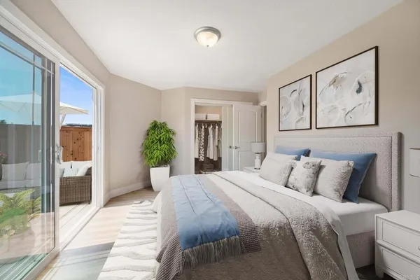 a bedroom with a large bed and a potted plant