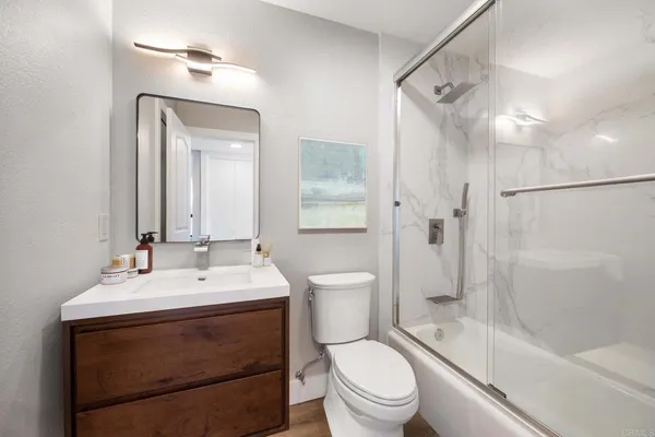 a bathroom with a sink a toilet and shower