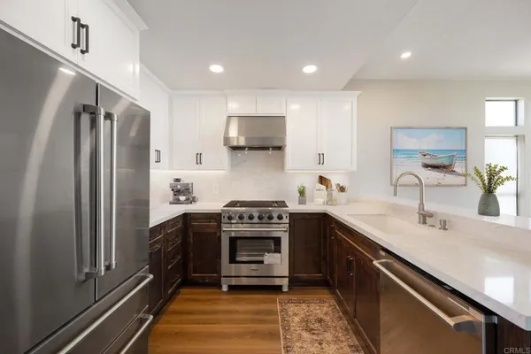 a kitchen with stainless steel appliances granite countertop a sink stove and refrigerator