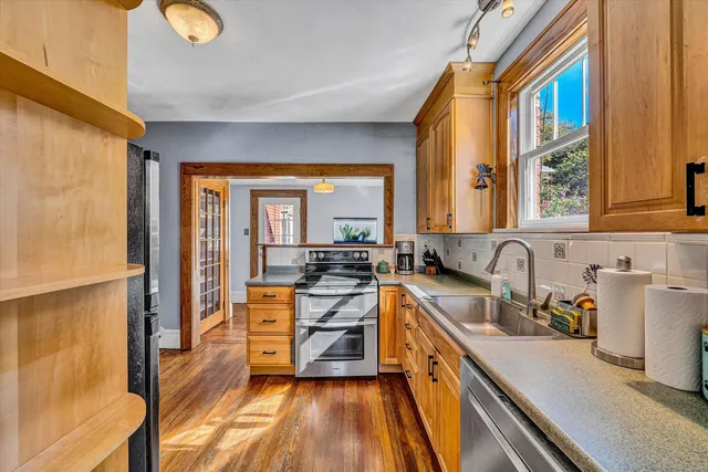 a kitchen with stainless steel appliances granite countertop a stove a sink and a refrigerator