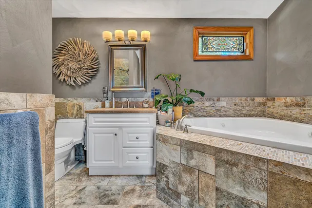 a bathroom with a bathtub sink and mirror