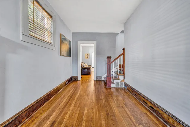 a view of a hallway with wooden floor and staircase