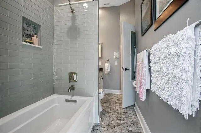 a bathroom with a granite countertop toilet sink and mirror