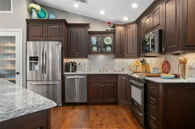 a kitchen with stainless steel appliances granite countertop a refrigerator and a sink