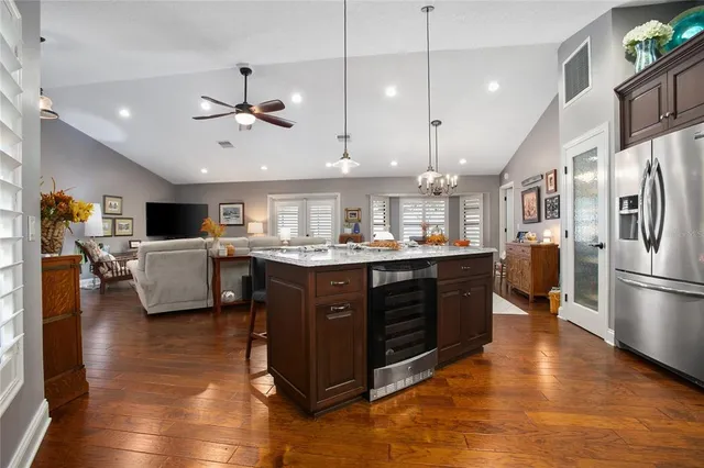 a kitchen with a refrigerator and wooden floor
