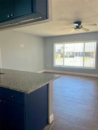 a room with granite countertop a sink and a large window