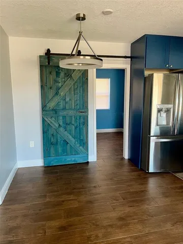 a view of a refrigerator in kitchen and empty room