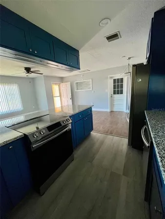 a kitchen with granite countertop a stove and a refrigerator