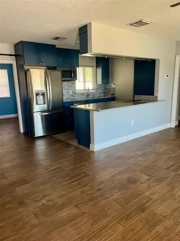 a large kitchen with kitchen island granite countertop a large counter top stainless steel appliances and cabinets