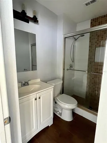 a bathroom with a granite countertop sink toilet and a shower