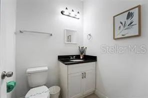 a bathroom with a granite countertop sink a toilet and a mirror