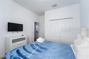 a bedroom with a bed and a flat screen tv