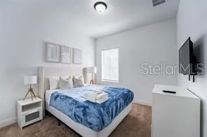 a bedroom with a bed and a flat screen tv