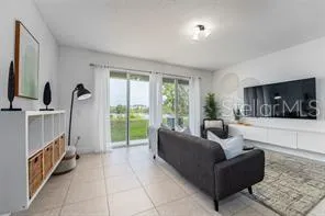 a living room with furniture a flat screen tv and a large window