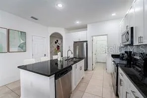 a kitchen with stainless steel appliances granite countertop a sink a stove and a refrigerator