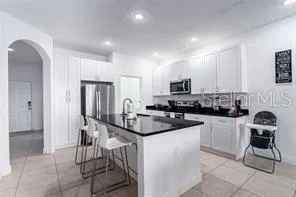 a kitchen with stainless steel appliances granite countertop a sink and a refrigerator