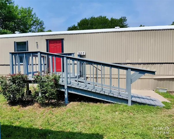 a view of a house with wooden deck and a yard