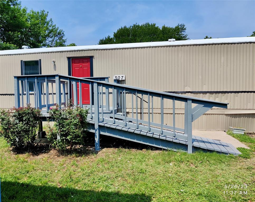 a view of a house with wooden deck and a yard