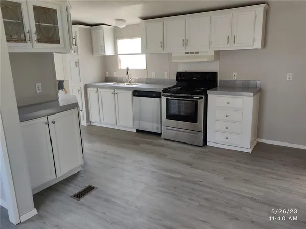 a kitchen with granite countertop white cabinets and white appliances