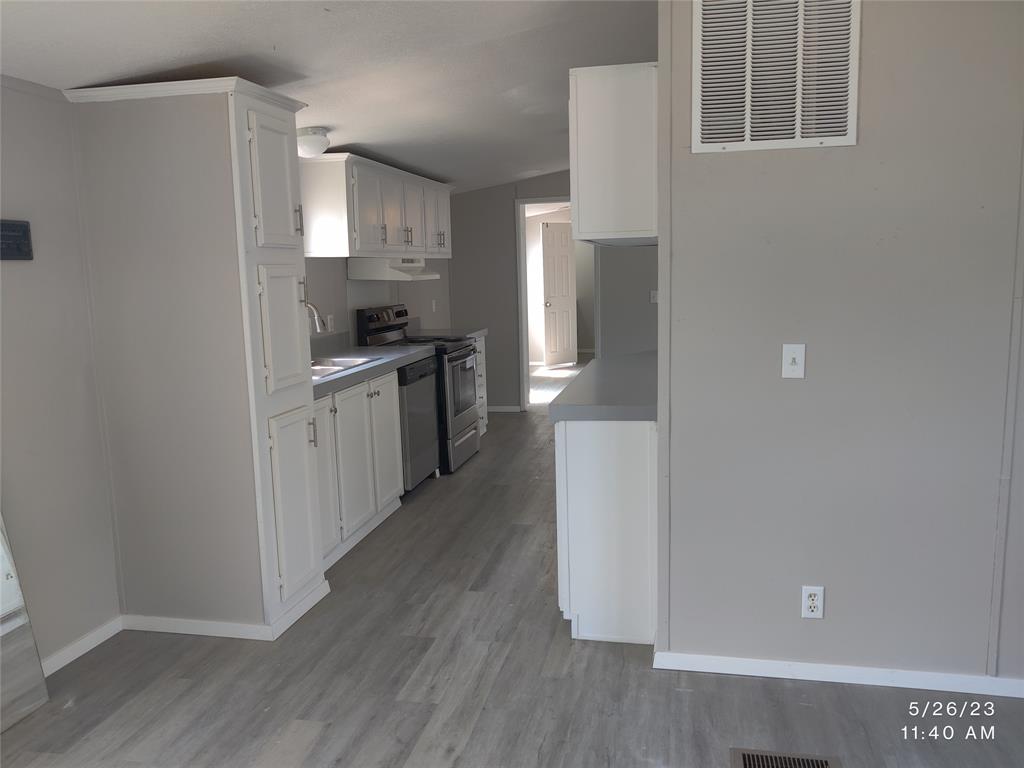 307 Jones Circle Pottsboro, TX 75076 - Photo 4 of 11 a kitchen with stainless steel appliances granite countertop a refrigerator a sink a stove and white cabinets with wooden floor