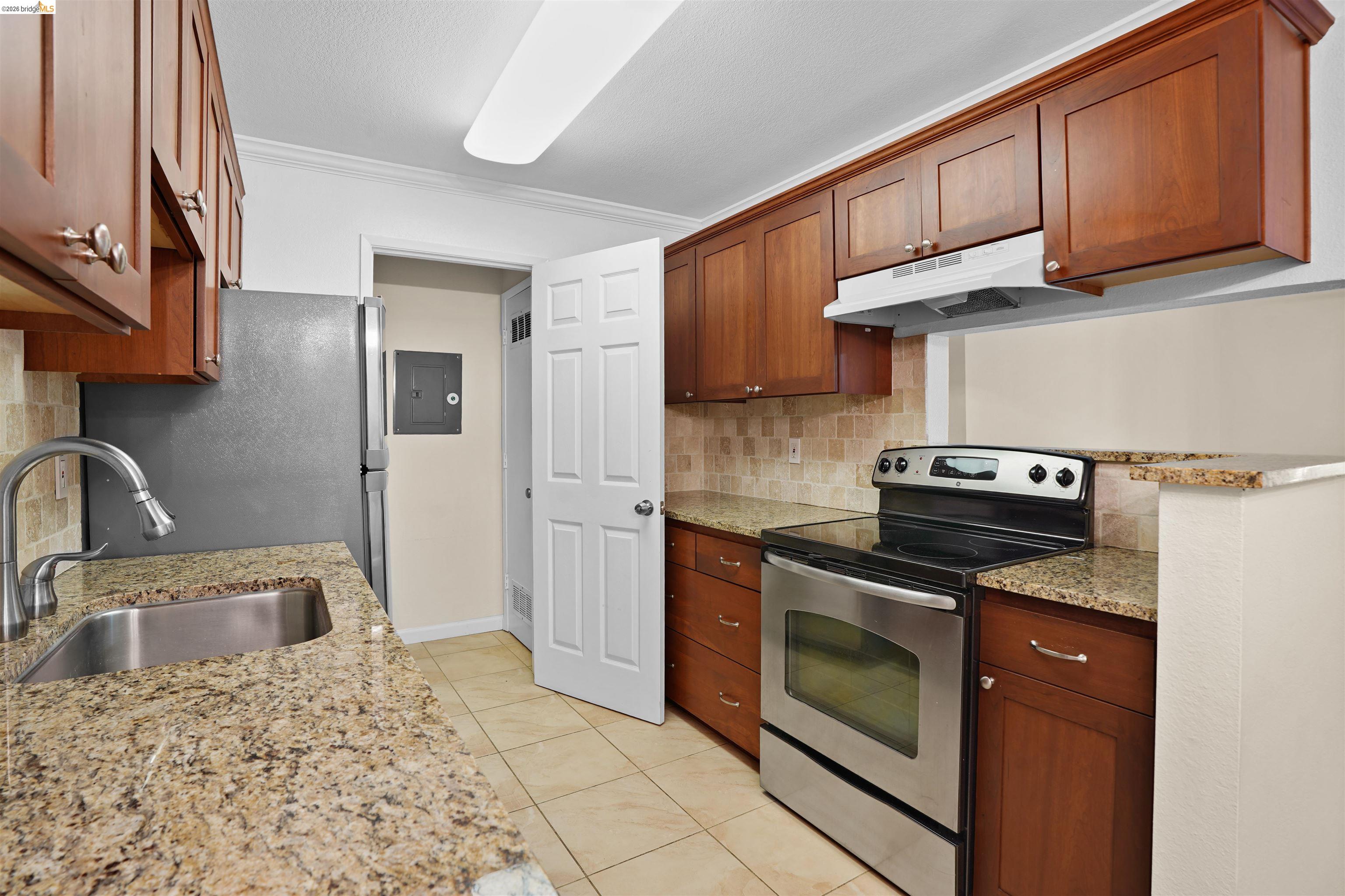 1505 Kirker Pass Road, Unit 214 Concord, CA 94521 - Photo 15 of 55 Kitchen featuring wood cabinetry, granite countertops, tile flooring, and stainless steel appliances