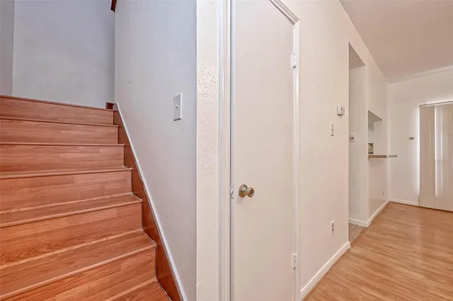 a view of a hallway with wooden floor and entryway