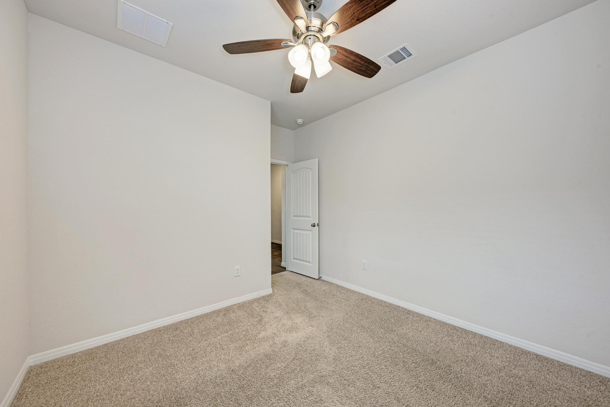 208 Abby Road Georgetown, TX 78626 - Photo 32 of 40 an empty room with a chandelier fan and a ceiling fan