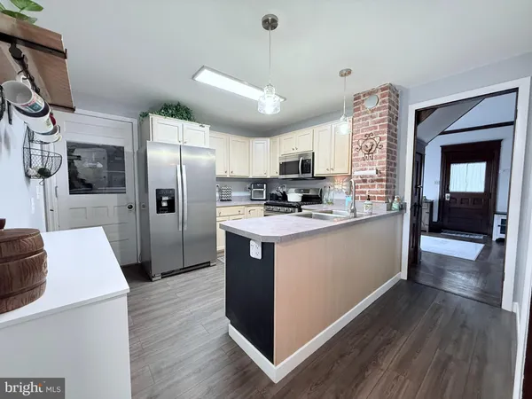 a kitchen with stainless steel appliances a refrigerator a stove a sink and a hard wood floors