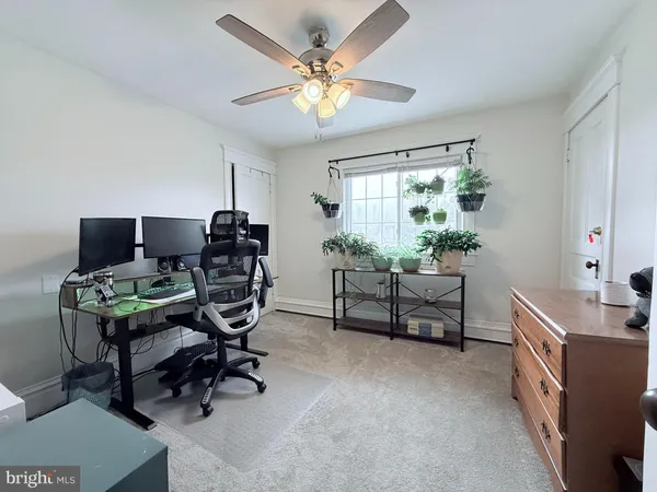 a view of a workspace with furniture and a window