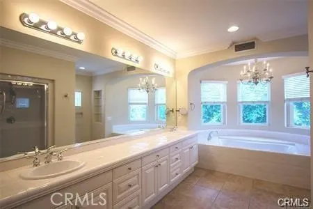 a bathroom with a large tub sink and large mirror