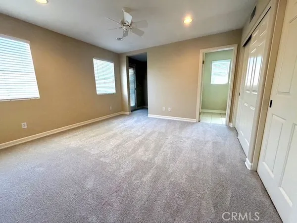 an empty room with windows and closet