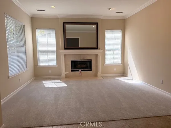 an empty room with windows and fireplace