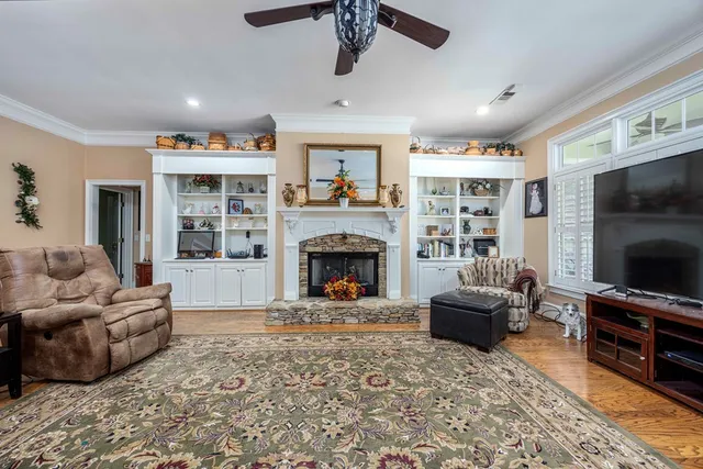 a living room with furniture a flat screen tv and a table