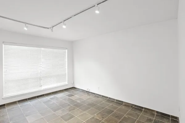 an empty room with white wall and tiles