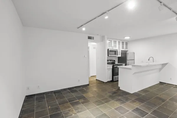 a view of kitchen with furniture and refrigerator