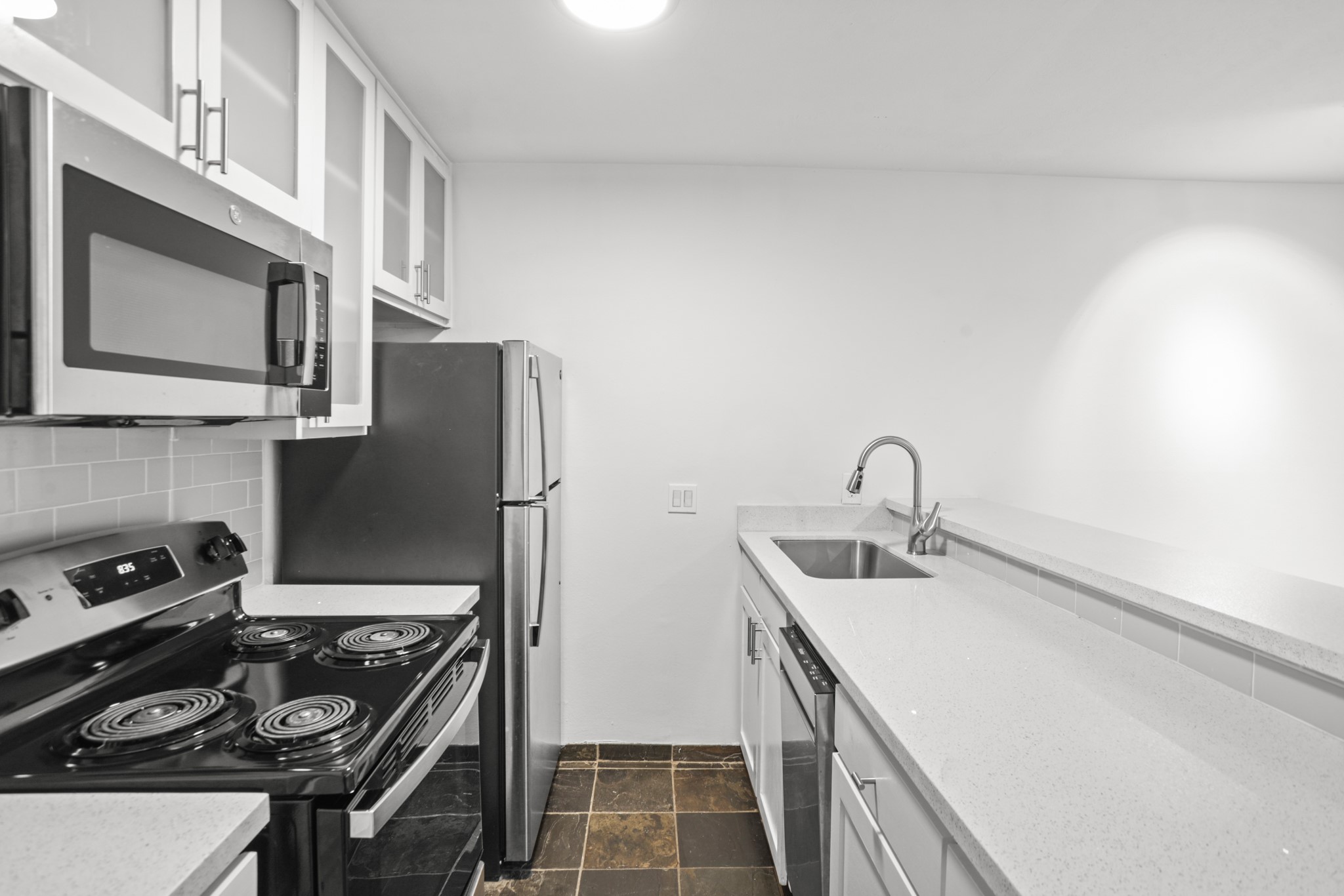 3602 Garrott Street, Unit 11 Houston, TX 77006 - Photo 7 of 34 a kitchen with stainless steel appliances granite countertop a sink stove and refrigerator
