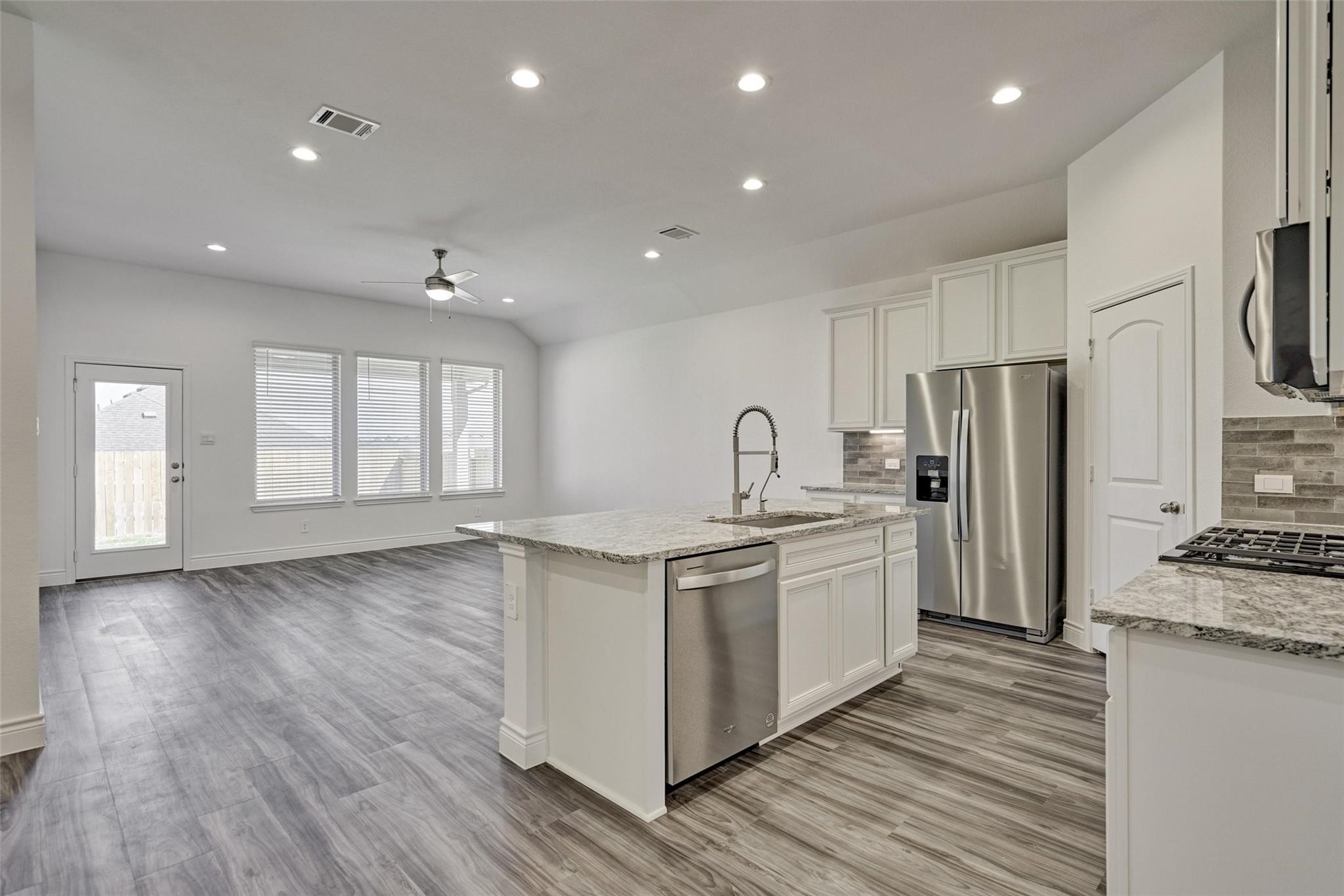 981 Youth Water Road Montgomery, TX 77316 - Photo 17 of 43 a kitchen with stainless steel appliances granite countertop a sink stove and refrigerator