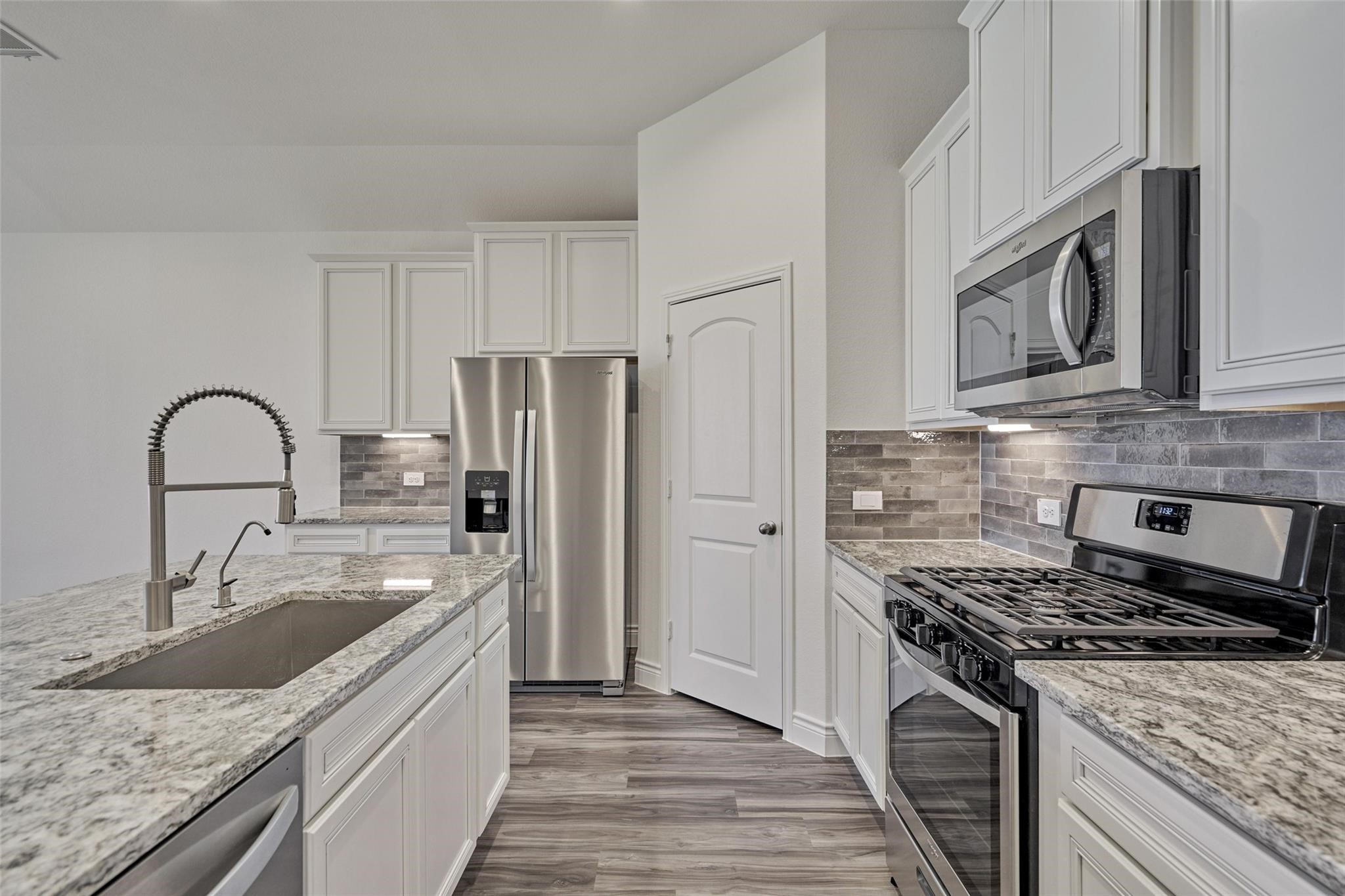 981 Youth Water Road Montgomery, TX 77316 - Photo 18 of 43 a kitchen with stainless steel appliances granite countertop a sink stove and refrigerator