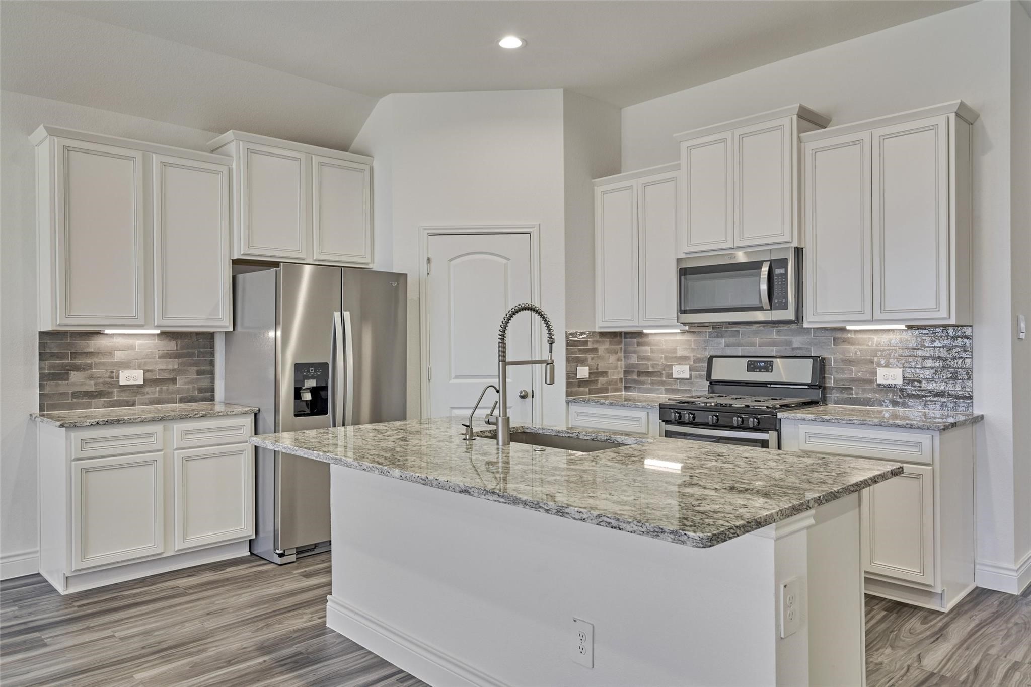 981 Youth Water Road Montgomery, TX 77316 - Photo 21 of 43 a kitchen with stainless steel appliances granite countertop a sink stove and refrigerator